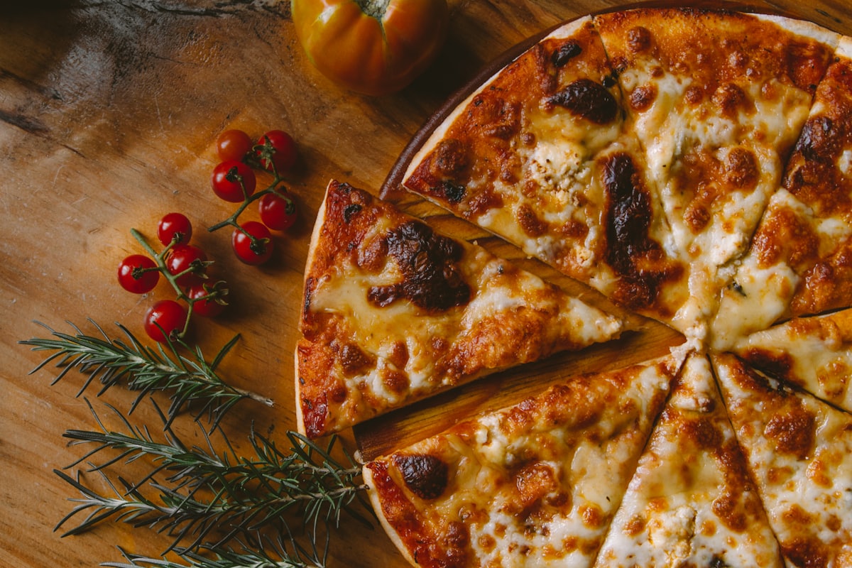 Wood-fired thin-crust pizza with rosemary and cherry tomatoes